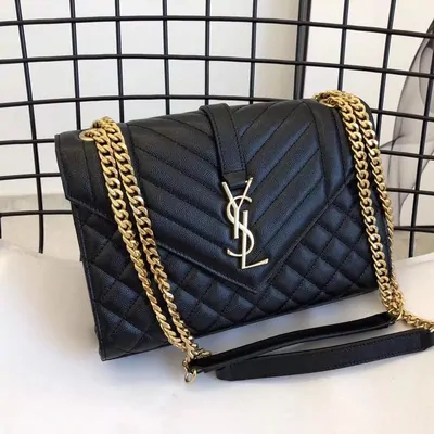 Black quilted chain-strap shoulder bag on a marble table