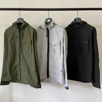 Three hooded utility jackets hanging on a rail